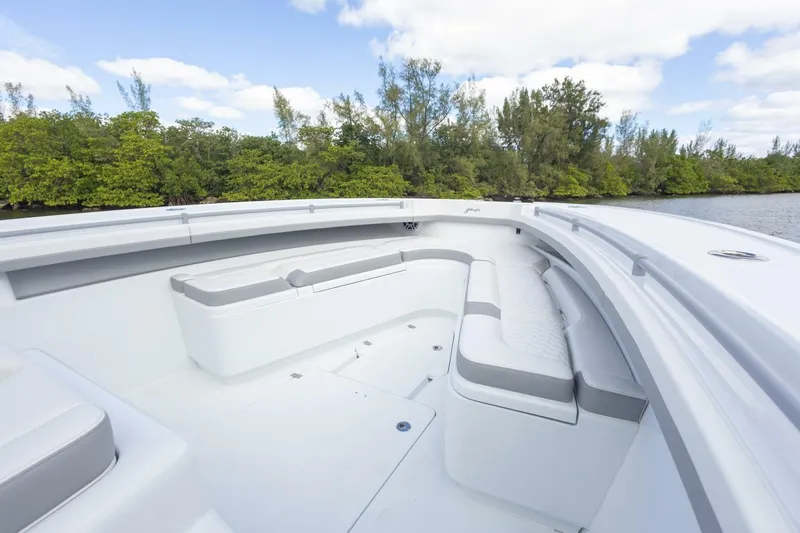  Yacht Photos Pics 2026 Yellowfin 42 Offshore boat with spacious seating, surrounded by lush greenery and calm waters.