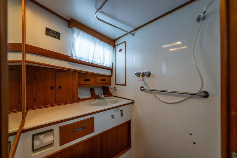Voyageur Yacht Photos Pics 1995 Grand Banks Aft Cabin 42 Classic bathroom with wooden cabinetry and shower.