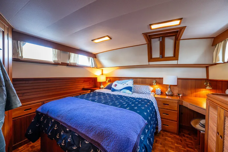 Voyageur Yacht Photos Pics 1995 Grand Banks Aft Cabin 42 Classic bedroom with wooden interior and cozy bedding.