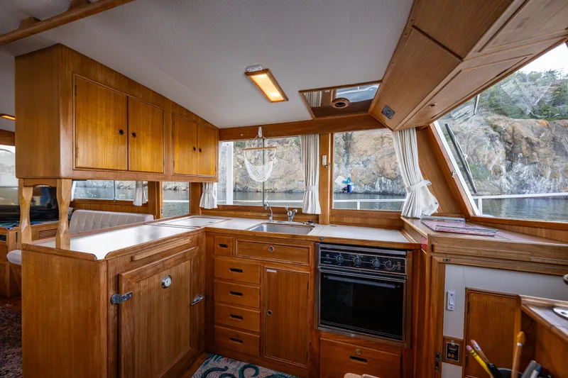 Voyageur Yacht Photos Pics 1995 Grand Banks Aft Cabin 42 Classic yacht interior with wooden cabinetry and scenic window view.
