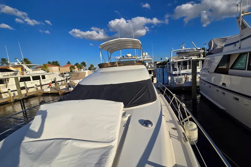 Solitude Yacht Photos Pics 1997 Sunseeker Manhattan 48 yacht docked at marina under clear blue sky.