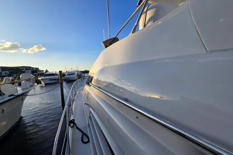 Solitude Yacht Photos Pics Sunseeker Manhattan 48 yacht docked at marina, reflecting sunset light, 1997 model.