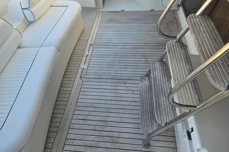 Solitude Yacht Photos Pics Sunseeker Manhattan 48 yacht deck with white seating and wooden steps, 1997 model.