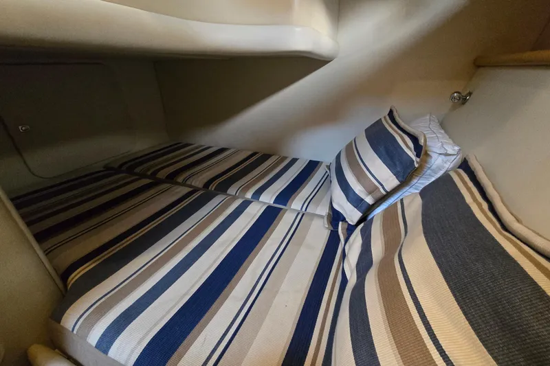 Solitude Yacht Photos Pics Cozy cabin bed with striped bedding in 1997 Sunseeker Manhattan 48 yacht.