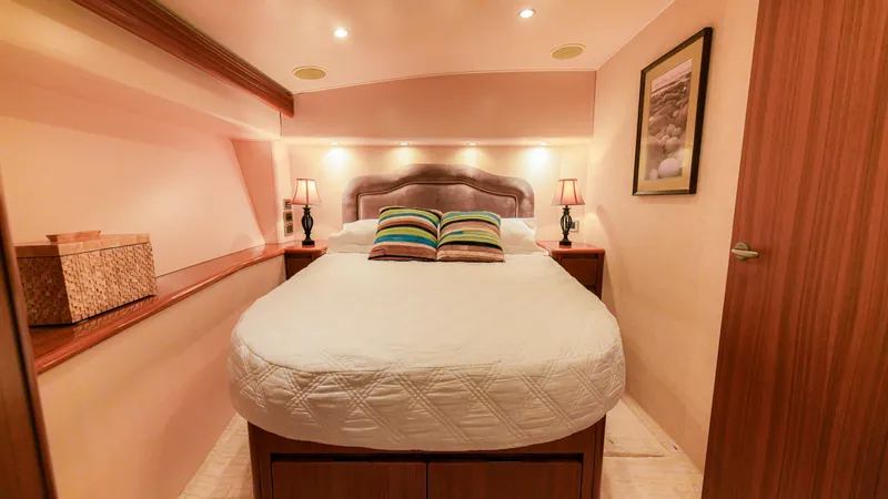 Manudito Yacht Photos Pics Cozy bedroom in a 2009 Viking 50C yacht with a double bed and ambient lighting.