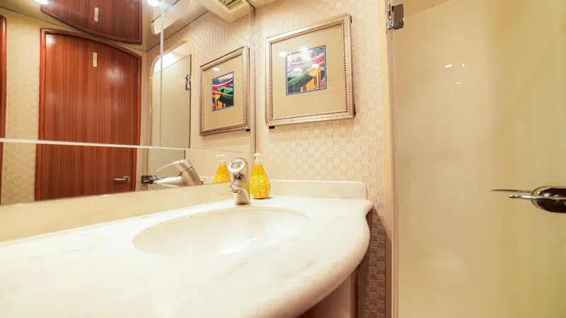 Manudito Yacht Photos Pics Luxurious bathroom in a 2009 Viking 50C yacht with marble countertop and framed artwork.