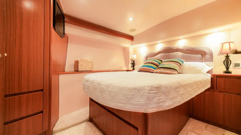 Manudito Yacht Photos Pics Luxurious bedroom in a 2009 Viking 50C yacht with wooden cabinetry and cozy lighting.