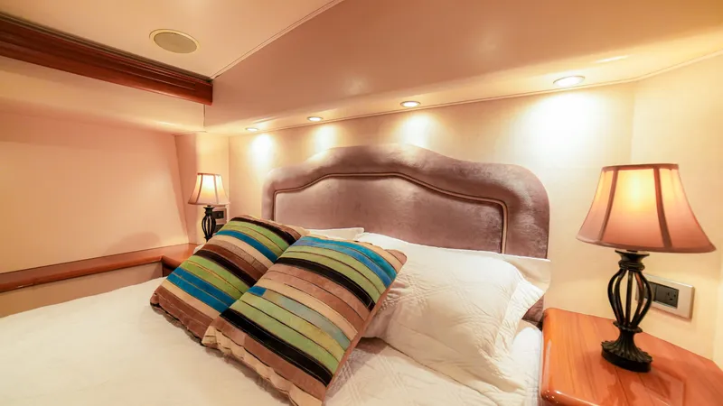 Manudito Yacht Photos Pics Luxurious bedroom in a 2009 Viking 50C yacht with plush pillows and ambient lighting.