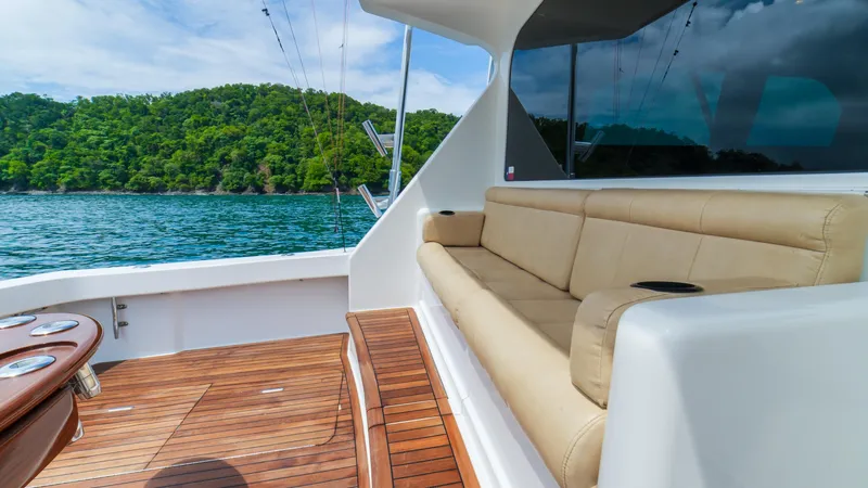 Manudito Yacht Photos Pics 2009 Viking 50C yacht with beige seating and wooden deck, scenic ocean view.