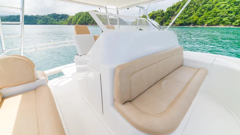 Manudito Yacht Photos Pics 2009 Viking 50C yacht interior with beige seating, cruising on clear waters near lush green islands.