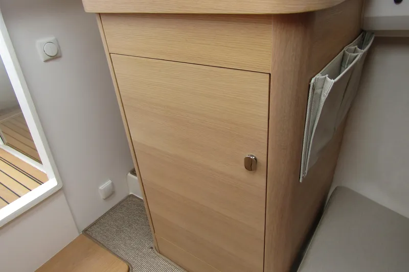  Yacht Photos Pics Wooden cabinet interior of 2025 Nimbus Weekender 9 boat, featuring sleek design and storage pocket.
