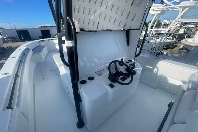  Yacht Photos Pics 2026 Contender 39 ST boat cockpit with steering wheel and seating, docked under clear blue sky.