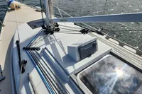 2017 Rustler 33 sailboat deck with rigging and hatch, on calm water.