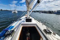 Sailing on a 2017 Rustler 33 yacht in a scenic harbor.
