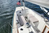 2017 Rustler 33 sailboat cockpit with American flag, featuring seating and winches on a calm sea.