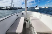 2017 Rustler 33 sailboat cockpit with cushioned seating, docked in a marina under a blue sky.