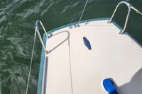 Bow of a 2017 Rustler 33 sailboat on water, featuring stainless steel fittings.