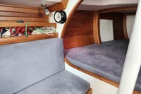 Interior of a 2017 Rustler 33 sailboat with wooden paneling and cozy seating.