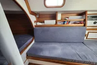 Interior of a 2017 Rustler 33 sailboat with cushioned seating and wooden accents.