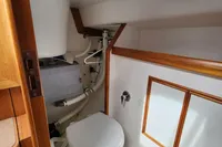 2017 Rustler 33 yacht bathroom with wooden trim and compact toilet.