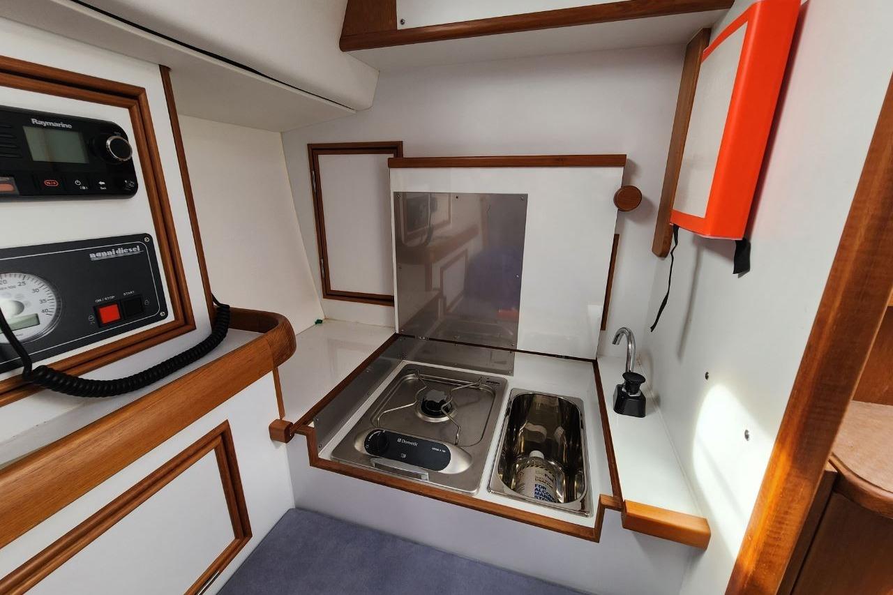 2017 Rustler 33 yacht interior with compact kitchen, stove, and sink.