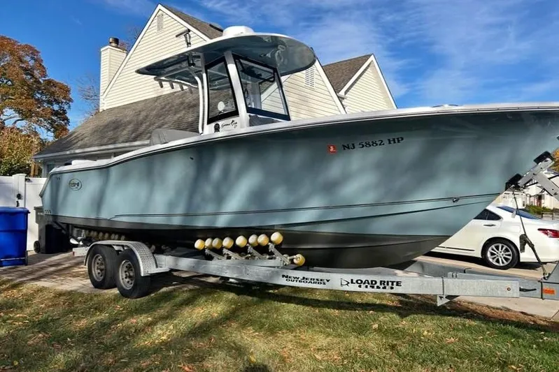  Yacht Photos Pics 2021 Sea Hunt Gamefish 27 Coffin Box boat on trailer in residential driveway.