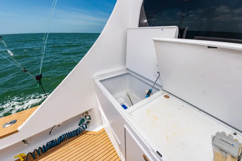 Carolina Girl Yacht Photos Pics 1993 Jarrett Bay Convertible boat deck with open storage, ocean view, and fishing equipment.