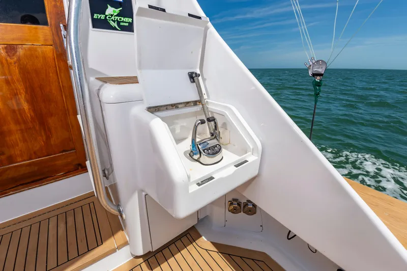 Carolina Girl Yacht Photos Pics 1993 Jarrett Bay Convertible boat cockpit with fishing equipment, ocean view, and wooden accents.