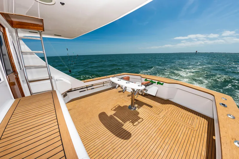 Carolina Girl Yacht Photos Pics 1993 Jarrett Bay Convertible yacht deck with ocean view, featuring wooden flooring and fishing equipment.