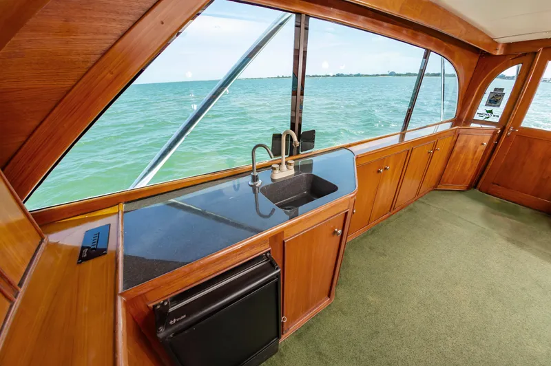 Carolina Girl Yacht Photos Pics 1993 Jarrett Bay Convertible yacht interior with wooden cabinetry and ocean view.