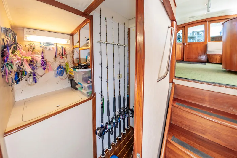 Carolina Girl Yacht Photos Pics 1993 Jarrett Bay Convertible interior with fishing gear storage and wooden stairs.