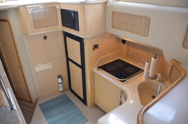 Don't Blink Yacht Photos Pics Interior of 2000 Sea Ray 400 Sedan Bridge yacht kitchen with stove, sink, and microwave.