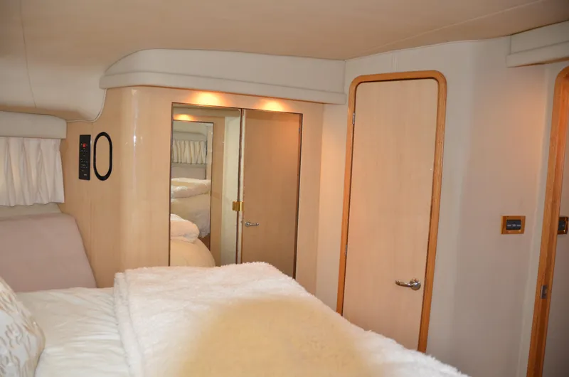 Don't Blink Yacht Photos Pics Interior of 2000 Sea Ray 400 Sedan Bridge yacht bedroom with cozy bedding and wooden accents.