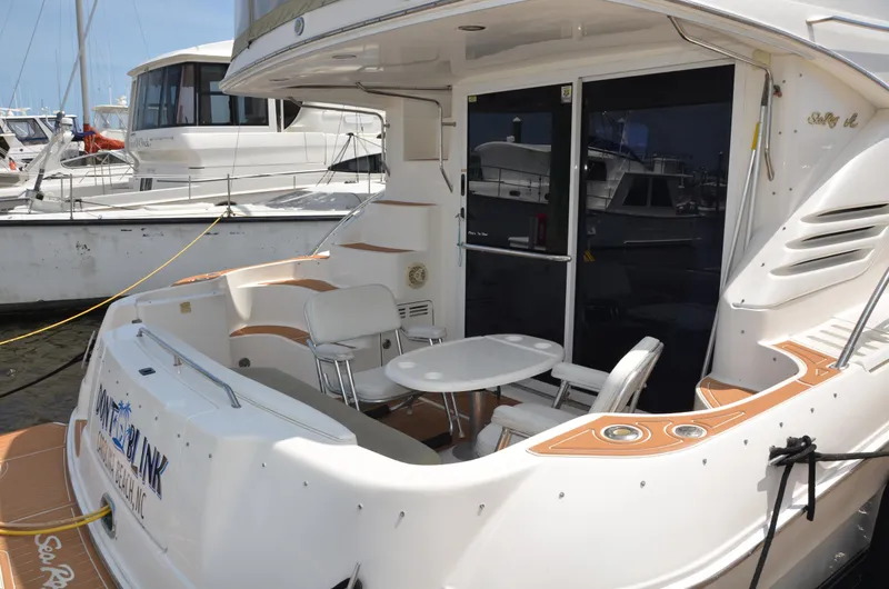 Don't Blink Yacht Photos Pics 2000 Sea Ray 400 Sedan Bridge yacht with outdoor seating and table on deck.