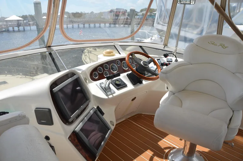 Don't Blink Yacht Photos Pics Interior view of 2000 Sea Ray 400 Sedan Bridge yacht cockpit with steering wheel and navigation screens.