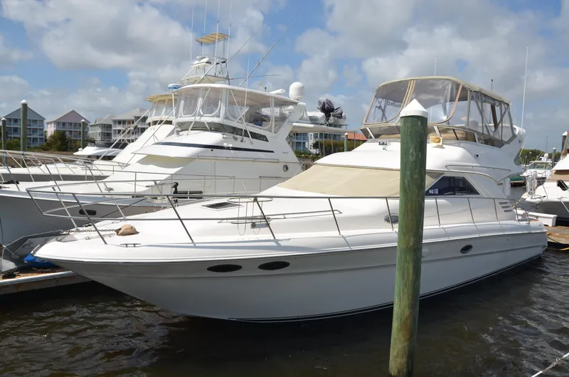 Don't Blink Yacht Photos Pics 2000 Sea Ray 400 Sedan Bridge yacht docked at marina under cloudy sky.