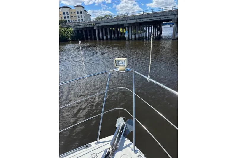 Yacht Photos Pics Bow view of 2004 Carver 466 Motor Yacht approaching a bridge on a sunny day.