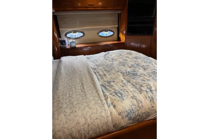  Yacht Photos Pics Luxurious bedroom interior of 2004 Carver 466 Motor Yacht with floral bedding and porthole windows.