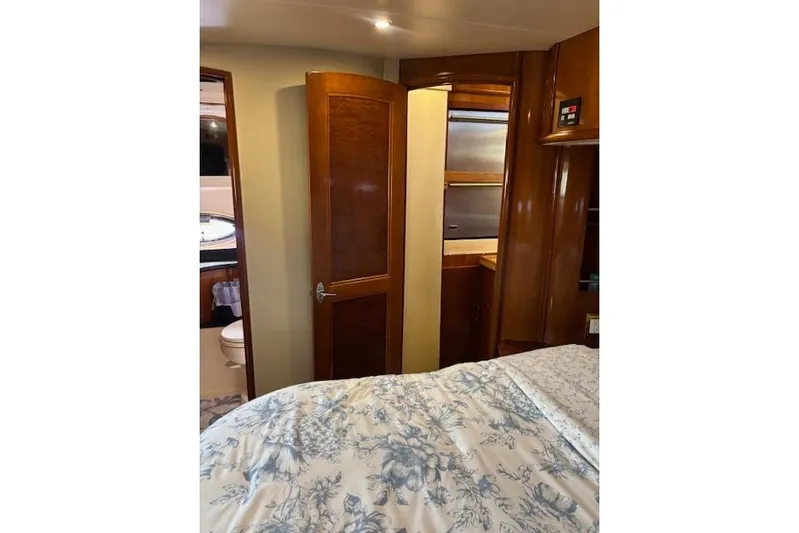  Yacht Photos Pics Interior of 2004 Carver 466 Motor Yacht bedroom with wooden cabinetry and floral bedding.