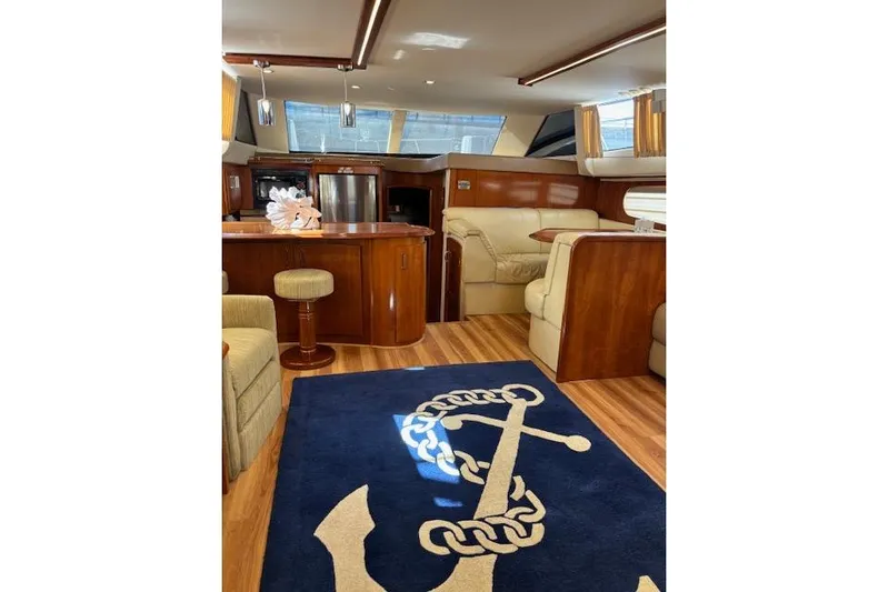  Yacht Photos Pics Luxurious interior of 2004 Carver 466 Motor Yacht with elegant wood finishes and anchor-themed rug.