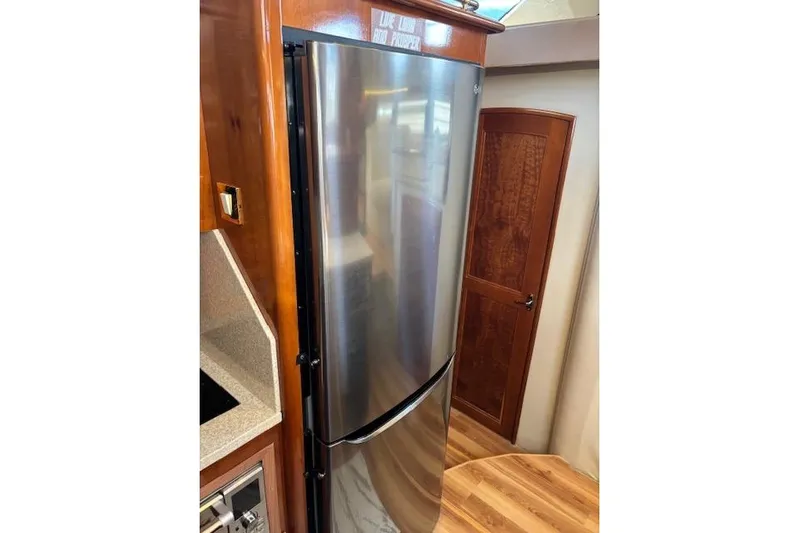  Yacht Photos Pics Stainless steel refrigerator in 2004 Carver 466 Motor Yacht interior, featuring wood accents.