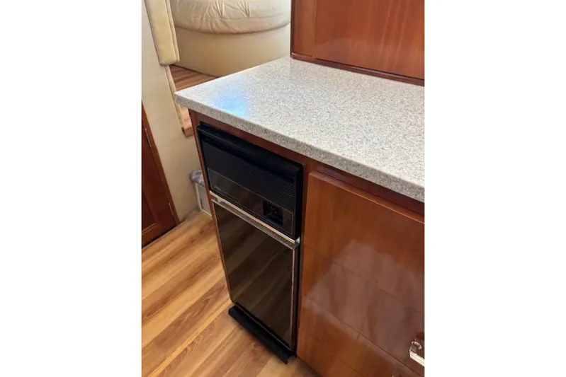  Yacht Photos Pics 2004 Carver 466 Motor Yacht interior with compact fridge and wooden cabinetry.