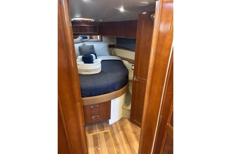  Yacht Photos Pics Luxurious cabin interior of 2004 Carver 466 Motor Yacht with wood finish and cozy bedding.