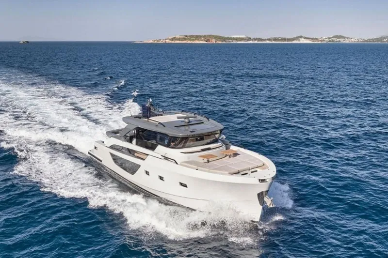  Yacht Photos Pics 2024 Bluegame BGX63 yacht cruising on open sea with distant coastline.
