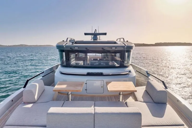  Yacht Photos Pics 2024 Bluegame BGX63 yacht on serene ocean at sunset, featuring luxurious deck seating.