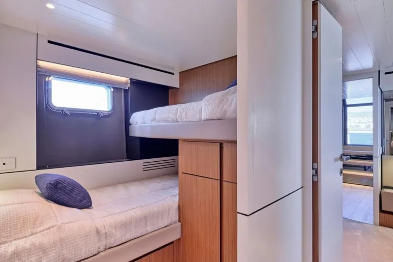  Yacht Photos Pics 2024 Bluegame BGX63 yacht interior with modern bunk beds and window view.