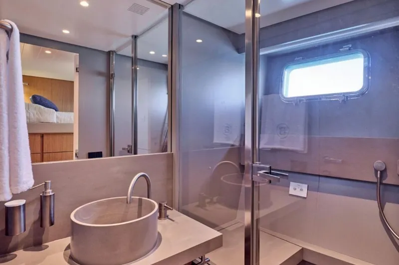  Yacht Photos Pics Luxurious bathroom interior of 2024 Bluegame BGX63 yacht with modern fixtures and window.
