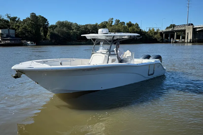 Lucky Penny Yacht Photos Pics 2022 Sea Fox 288 Commander boat on a calm river near a bridge.
