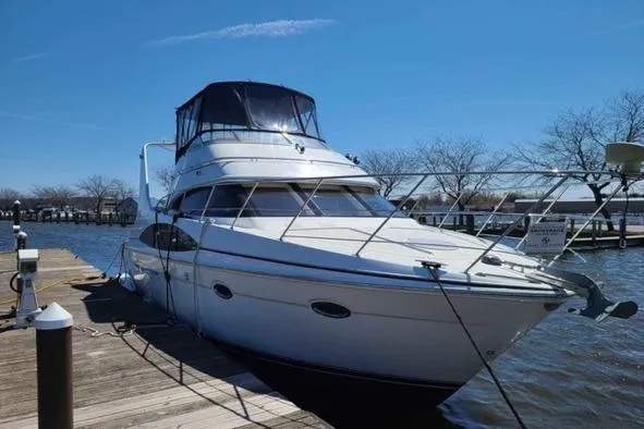  Yacht Photos Pics 2002 Carver 410 Sport Sedan yacht docked at a marina under clear blue skies.