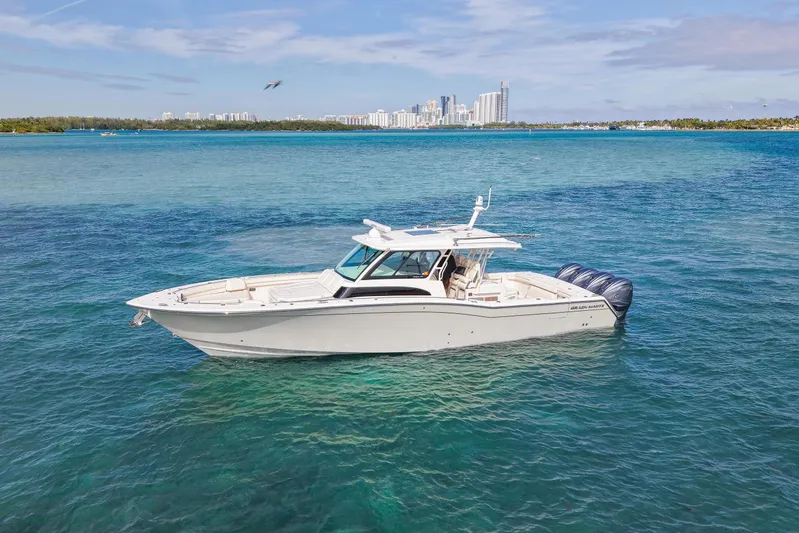  Yacht Photos Pics 2022 Grady-White Canyon 456 boat on clear blue water with city skyline in background.